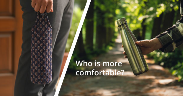Navy printed cotton water bottle carrier held by hand beside a bare steel bottle on a tree-lined path